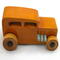 This handmade wooden toy car is based on a 1932 Ford Sedan Hot Rod. It is hand-finished with multiple coats of amber shellac and trimmed with black and grey acrylic paint.