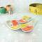 photo showing three abstract triangle copper enamel buttons with yellow, orange, and olive green torch fired enamel on copper. In photo are thread spools and measuring tape for vignette.