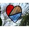 Stained glass heart in red, white, and blue with nature in the background