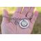 Lifestyle image of hand holding silver photo charm bracelet with dog photo, paw print, and forever in my heart charm.