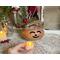 This image shows the battery-operated candle included in your purchase. The candle lights up the carved elf face and has a timer setting.