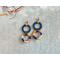 Colorful threads wrapped tightly around two circles give these fun earrings a tropical vibe.
2 x 7/8 in, 
gold plated ball post and backing