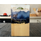 A handcrafted cheese board made of solid maple hardwood featuring a mountain lion scene in blue resin with gold accents.