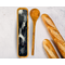 A handmade olive wood spoon rest and spoon set with a modern, monochrome resin artwork featuring ribbons of pure silver.