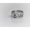 sterling silver ring with an anchor an the word til on it in black