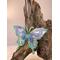 resin butterfly sun catcher hanging on natural wood piece in indoor lighting, side view