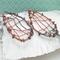 woven copper wire large dangle earrings with 6mm turquoise and copper composite gemstone cabochon, photo shows earrings