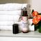 A roller bottle of Blemish Away by Whole Self Aromatherapy on spa countertop, lid off, towels arranged nearby, creating a serene ambiance.