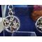 Detail of round dangle that has a rhinestone encrusted leaf pattern in the center.