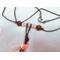 Rose quartz beads on a brown leather cord.