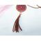 A leather tassel hanging from the bottom of a resin, stained glass pendant