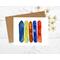 Greeting card with watercolor snowboards of yellow, blue, brown orange.