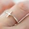 Chic sterling silver sideways cross ring on finger, perfect for daily wear with a playful faith twist.

