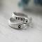  Two sterling silver rings with "SAMI" and paw prints on a white surface. 
