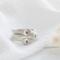  Three sterling silver stackable rings with lowercase initials "a," heart, and "t" on a white  background with dried flowers
