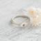 A sterling silver stackable rings with a heart, on a white  background with dried flowers
