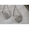 Sterling silver trillion shape imprinted with a mandala design hanging from sterling silver chain from two corners and a sterling ear wire. 