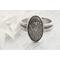 Elegant sterling silver wildflower ring in a box, surrounded by white petals, showcasing its handmade Alaskan craft.

