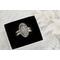 Close-up of a sterling silver wildflower ring with intricate floral etching, displayed in a black velvet box.

