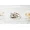Three sterling silver name rings with "Sophia" and "Liam" plus a heart ring on a white textured surface. 
