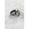 Sterling silver ring featuring chunky turquoise free form stone with silvery pyrite inclusions and a floral textured band.