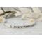 Sterling silver cuff bracelet stamped with kids names in a delicate handwritten font with a stamped for detail on both sides.