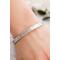 A close-up of a sterling silver floral cuff bracelet worn on a wrist, showcasing its elegant design and fit.