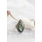 Silver ring with pear-shaped faceted labradorite featuring blue-green opalescent flashes serrated bezel and bead detailing around the bezel.