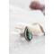Silver ring with pear-shaped faceted labradorite featuring blue-green opalescent flashes serrated bezel and bead detailing around the bezel.