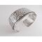 Wide sterling silver bracelet with mandala textured overlay.