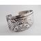 Wide sterling silver bracelet with floral textured overlay.