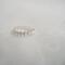Close-up of a sterling silver daisy ring with embossed floral design on a soft, blurred background.
