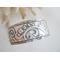Wide sterling silver cuff bracelet with layered scrollwork pattern. 