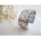 Wide sterling silver cuff bracelet with layered scrollwork pattern. 