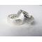 "Two silver bands with personalized engraving, 'JOHN' and 'PSALMS" visible, on a white fabric background."
