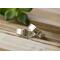 Two sterling silver wedding bands, one hammered, on rustic wood with green leaves backdrop, showcasing customizable texture options.