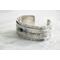 Sterling silver cuff bracelet with embossed arrow overlay accented with a genuine turquoise cabochon. 