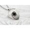 Shield shaped sterling silver pendant with floral patterned moon and faceted black onyx cabochon. 