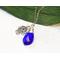 Image is of a Blue Crystal Teardrop Pendant with a Silver Hama Hand charm wire wrapped on a chain. 25" long