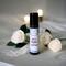 Let's Limbo Aromatherapy Roller on a white table with white lace, roses and candles in the background commonly found at a wedding venue.