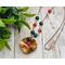 Necklace with wavy copper pendant flame colored to bring out red and yellow hues, red agate, malachite, and citrine beads on copper chain.