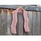 Display of the Zig Zag Crochet Scarf on a hanger in front of a wooden fence.