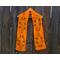 Orange scarf with leaves along the length. It is on a hanger in front of a wooden fence.