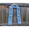Snowman outlines along a light blue scarf in front of a wooden fence.
