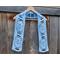 Display of the Easter Crochet Scarf on a hanger in front of a wooden fence.