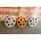 front view of a gold and silver miniature movie reel magnets hanging on fridge