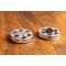 top view of a silver miniature movie reel magnet sitting on a wooden table