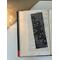 black and white flower bookmark on a book on a white table. Light brown table runner with fairy lights in a jar