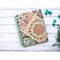 A handmade blank notebook with turquoise lined paper that has a paisley cover