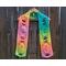 Display of the Easter Crochet Scarf on a hanger in front of a wooden fence.
